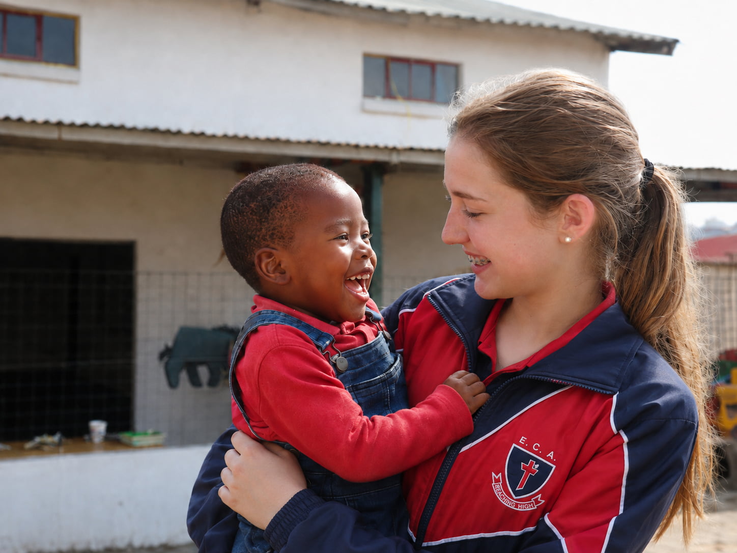 Elevate Christian Academy learner serving a young child through community outreach
