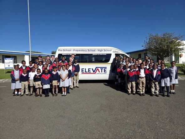 Elevate Christian Academy learners gathered with the ECA school bus